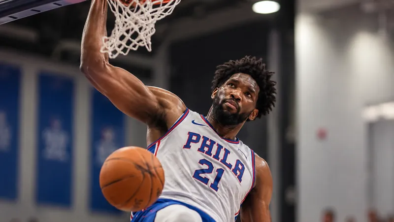 Satirical sports photo of a Philadelphia big man finishing a dunk during an indoor scrimmage.