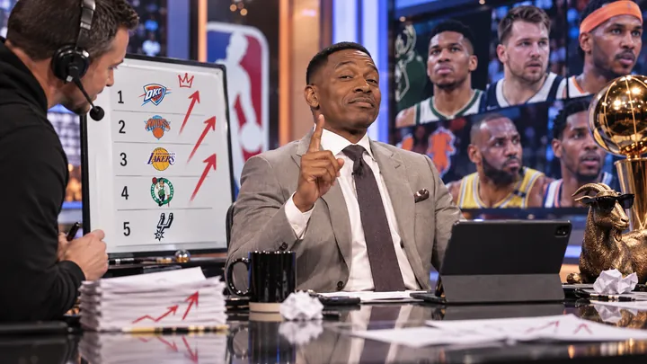 Satirical photorealistic NBA studio analyst confidently presenting offseason power rankings and predictions with charts and basketball graphics behind him.