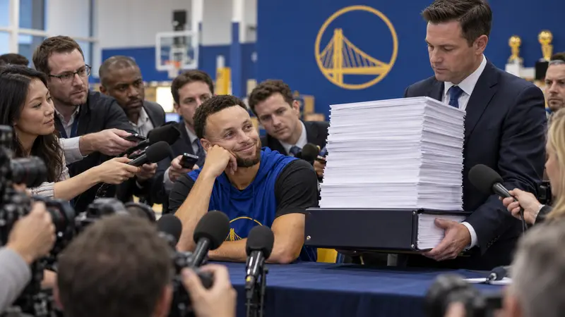 Photorealistic satire of Steph Curry smiling at a press conference beside an enormous stack of blank paperwork.